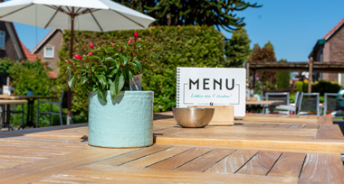 Een tafel met menukaart op het terras van Fletcher Hotel-Restaurant De Gelderse Poort